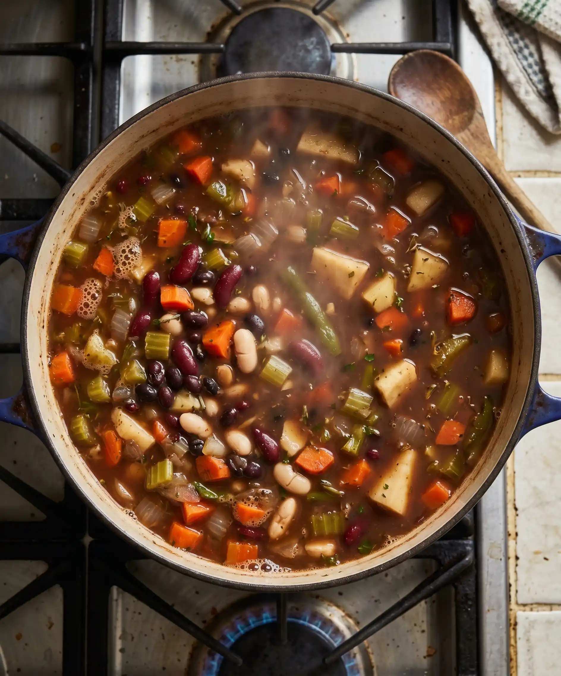 A top-down shot of a large pot of hearty homemade vegetable and bean soup simmering on a stovetop — rustic, steam rising, vegetables and beans visible through a rich broth — warm, nourishing, and deeply nostalgic.